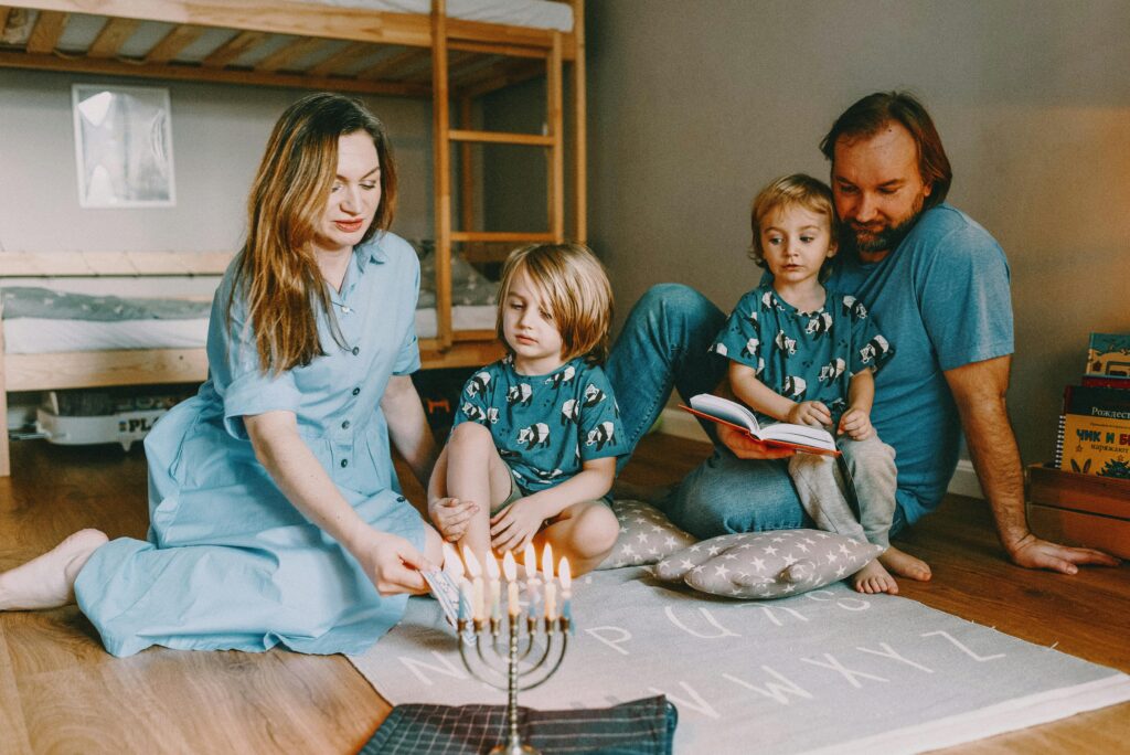 A family gathers to celebrate Hanukkah, lighting a menorah in a cozy home setting.